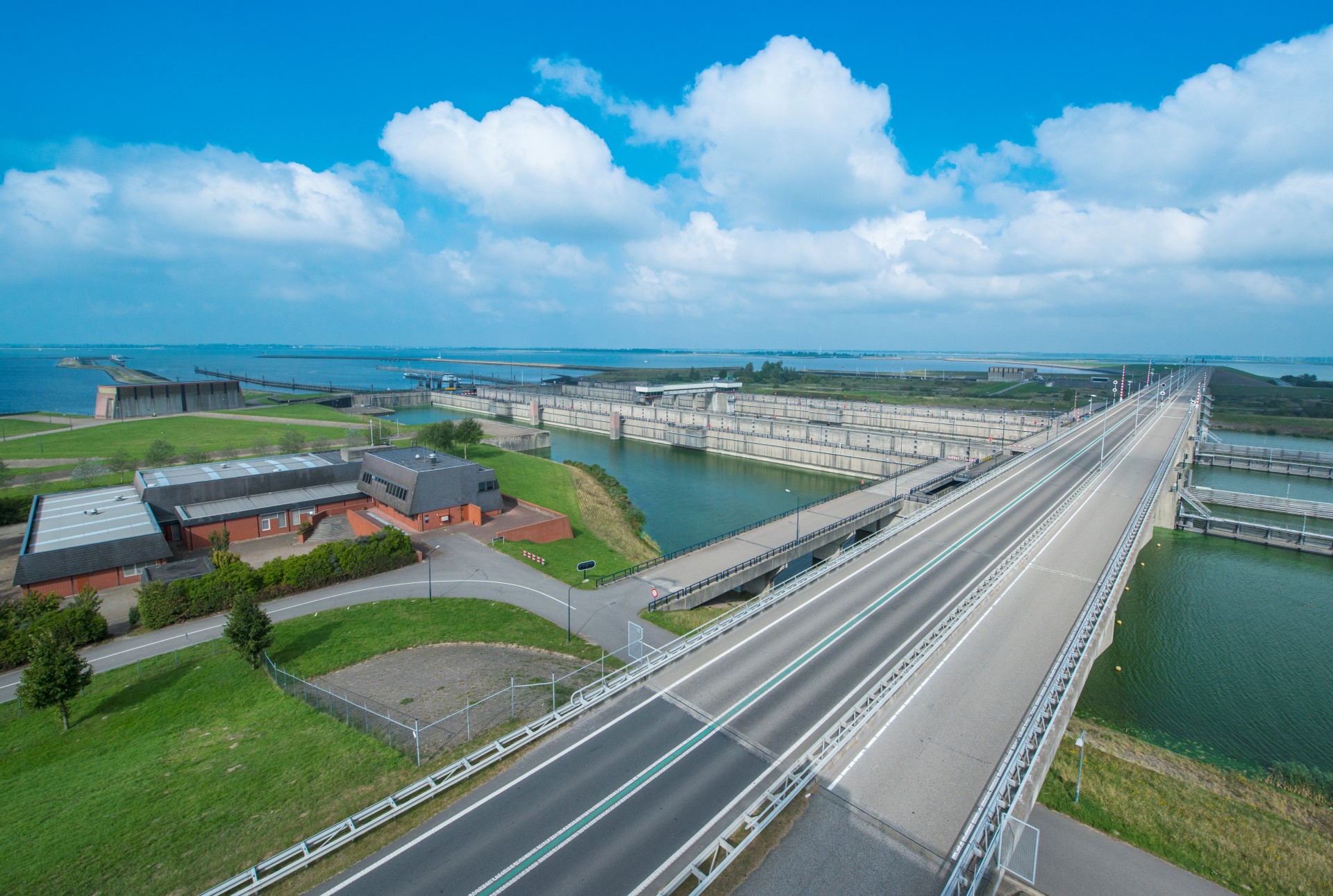 Foto van een landschap wat is doorsneden door watergangen, wegen en bebouwing.